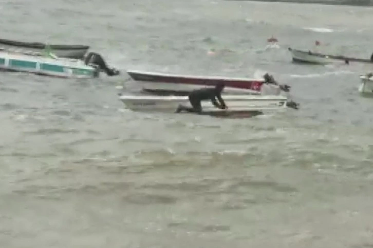 Batan teknesini kurtarmak için dalgalara aldırmadan denize girdi