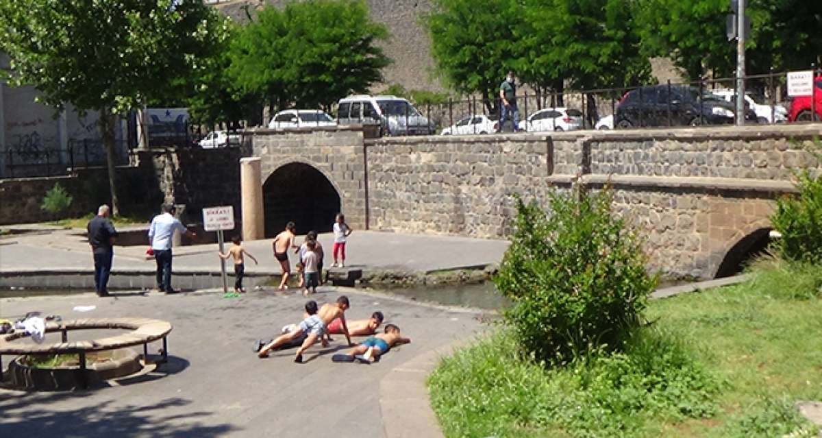 Diyarbakır'da sıcaktan bunalan çocuklar tehlikeye rağmen süs havuzlarını doldurdu